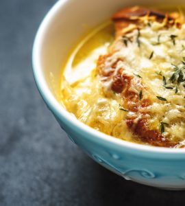 French onion soup in blue ceramic bowl horizontal