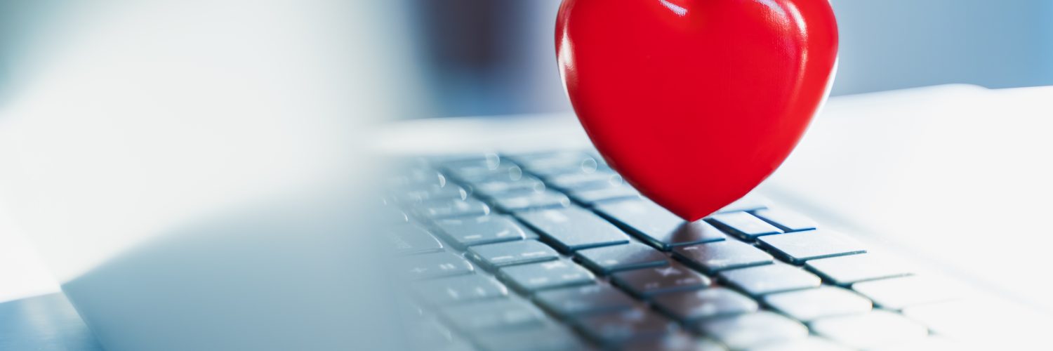 Big red heart on laptop keyboard. Valentine's day holiday concept. Online love, remote communication on internet, social networks. Virtual dating, calls and technology.Quarantine,coronavirus covid-19.